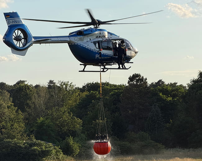 Waldbrand in der Wahner Heide - Feuerwehr Rösraht mit bis zu 200 Einsatzkräfte im Einsatz 2 Löschhubschrauber mit Bambi Bucket. Bild: Feuerwehr Rösraht